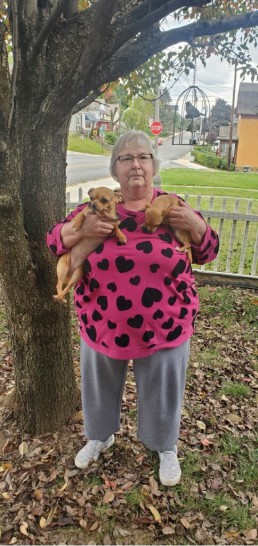 Mary Lou smiles with her two small dogs