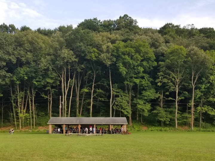 Group of teens in grass at camp.