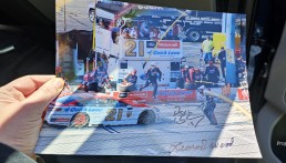 Hand holding autographed photo of Nascar driver.